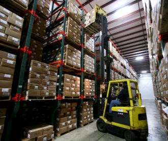 Warehouse employee using a forklift to place a pallet
